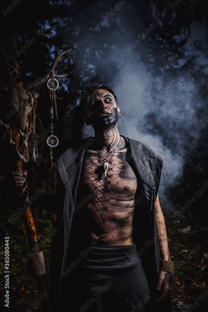 Sorcerer with marks on his body in the forest Sorcerer with marks on his body in the forest