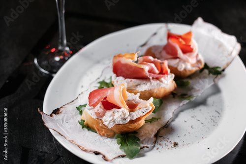 Set of snacks and glasses of wine. Bruschetta with cheese and salmon on a wooden board, served with red wine close up.