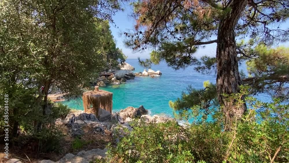 Sunbed and sun shade on a wooden sun deck on the rocks, next to wavy sea. Romantic holiday and honeymoon view for couples. Sunbed and sun shade on a wooden sun deck on the rocks, next to wavy sea. Romantic holiday and honeymoon view for couples.