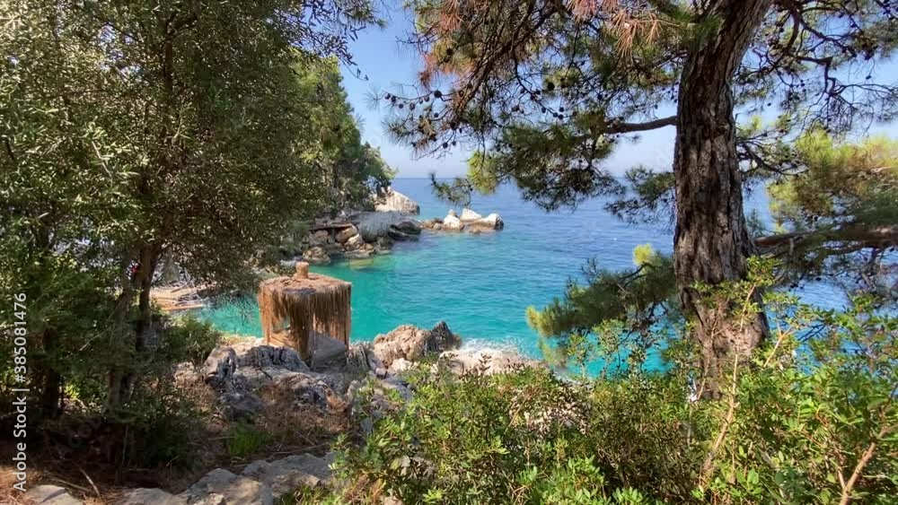 Sunbed and sun shade on a wooden sun deck on the rocks, next to wavy sea. Romantic holiday and honeymoon view for couples. Sunbed and sun shade on a wooden sun deck on the rocks, next to wavy sea. Romantic holiday and honeymoon view for couples.