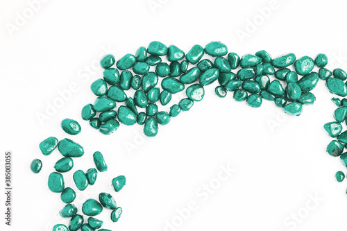 texture of stones on a white background. beautiful turquoise pebbles in water drops. top view, copy space