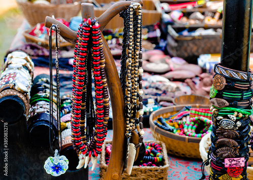 Decorations and accessories of different colors on the table. Beads, bracelets, watches on the table. Sale at the fair. Boho. © elenatkacheva
