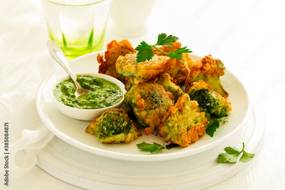 Fried broccoli in batter with green sauce. Selective focus Fried broccoli in batter with green sauce. Selective focus