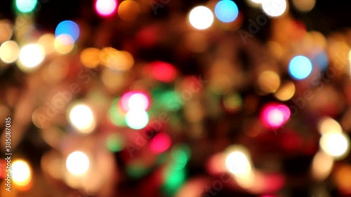 Bokeh effect of blurred holiday lights twinkling in tinsel for a festive background
