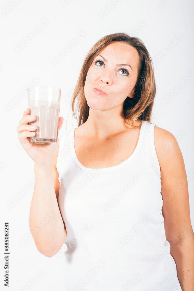 blond woman holding a glass of chocolate milk and smiling blond woman holding a glass of chocolate milk and smiling