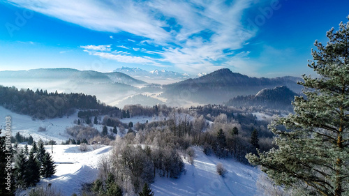 Winter in the white mountains and famous winter ski resort aerial view. Sunny winter day in alpine mountains. Winter in Tatra mountains, Austria, Switzerland, Italy, Poland.