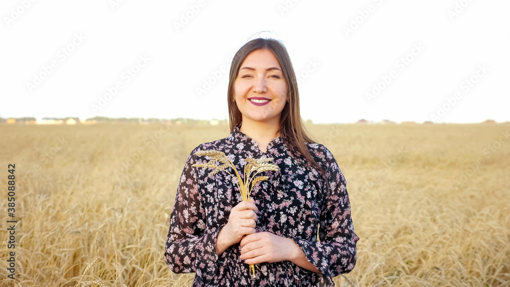 Portrait of a brunette woman with a bouquet of ears of ripe wheat in a field. Portrait of a brunette woman with a bouquet of ears of ripe wheat in a field.