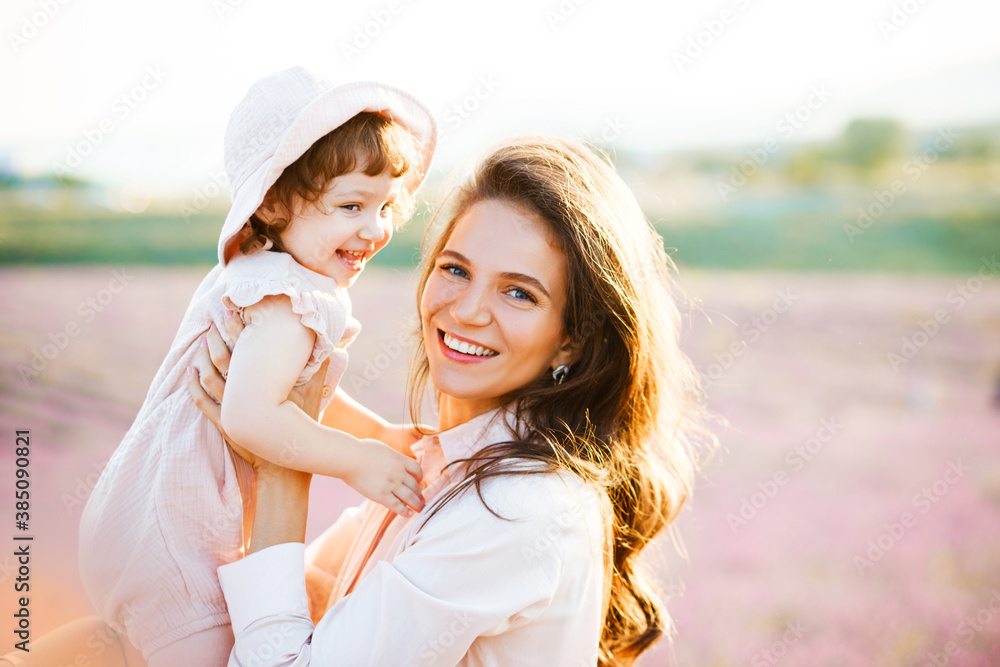 Happy family in a field at sunset. The kid smiles at his mother Happy family in a field at sunset. The kid smiles at his mother
