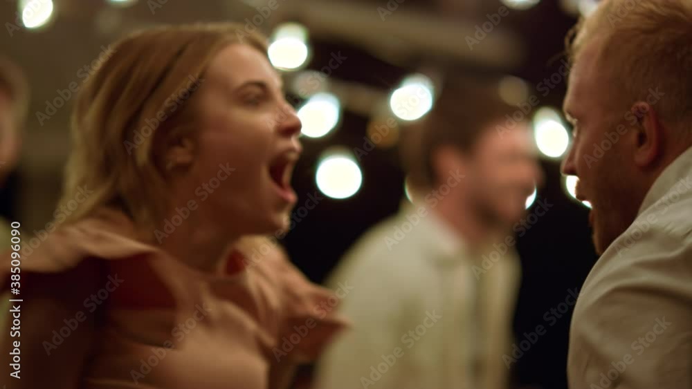 Friends jumping during dance. Positive couple having fun at new year party Friends jumping during dance. Positive couple having fun at new year party