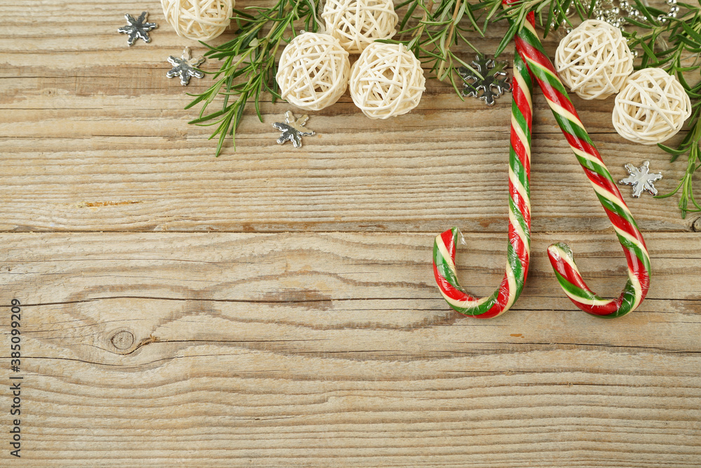 Christmas composition of Christmas tree toys, garlands, ribbons and caramel candies with Copy space on a wooden background for a greeting card Christmas composition of Christmas tree toys, garlands, ribbons and caramel candies with Copy space on a wooden background for a greeting card