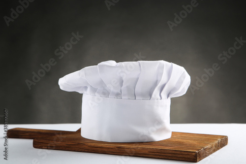 Chef hat with cutting board on black background