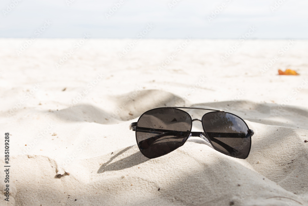 Eyewear placed on the sand at the beach.