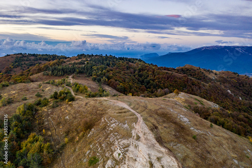 panoramic view of yellow autumn mountains against a background of blue haze and storm clouds filmed from a drone