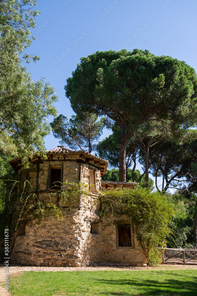Vertical view of old house, a sunny day, in El Capricho park, in Madrid, Spain Vertical view of old house, a sunny day, in El Capricho park, in Madrid, Spain