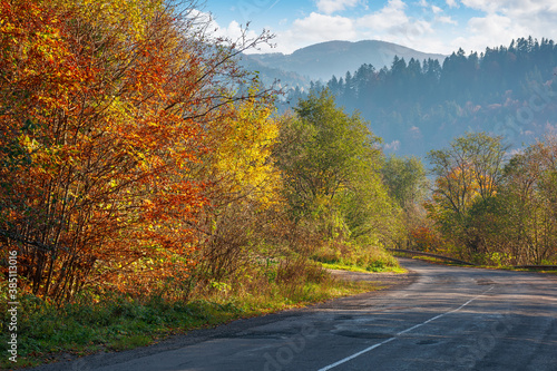 old asphalt road in mountains. beautiful autumn scenery on a sunny day. trees in colorful foliage. countryside journey on a weekend concept