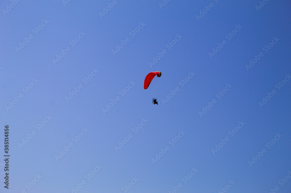 Parapente motorizado voando com o fundo do céu azul Parapente motorizado voando com o fundo do céu azul