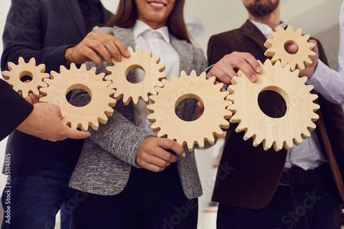 Obraz na plátně Company employees joining cogwheels as metaphor for effective business system an