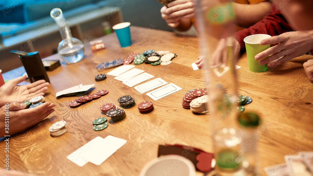 People playing poker and smoking weed. Poker chips and cards, bong for smoking marijuana on the table. Home party