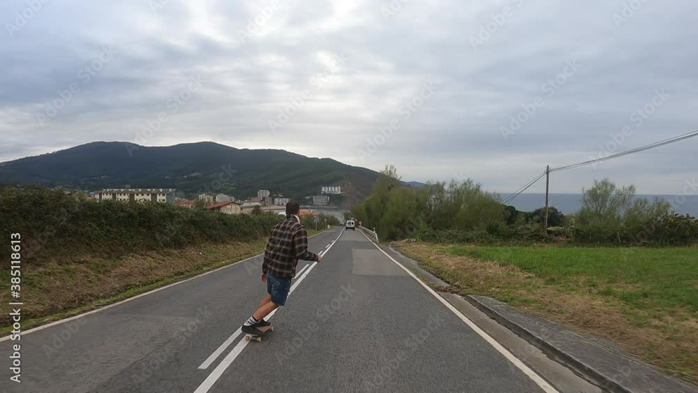 Young boy gliding with a longboard down the road Young boy gliding with a longboard down the road