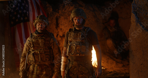 Confident soldiers standing against fire at night