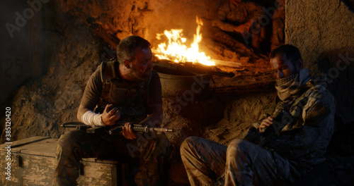 Angry military men resting near fire
