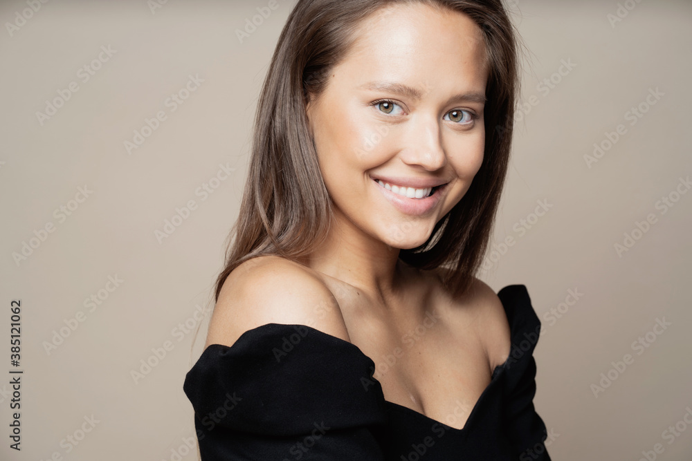 Naklejka premium Studio photography for advertising cosmetics or jewelry. portrait of a woman of European appearance, brunette with long hair, looking at the camera and smiling.