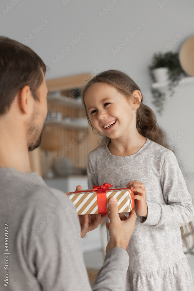 Child daughter congratulating dad and giving him gift box