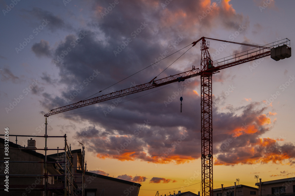 Silhouette of a crane at a construction site at sunset Silhouette of a crane at a construction site at sunset