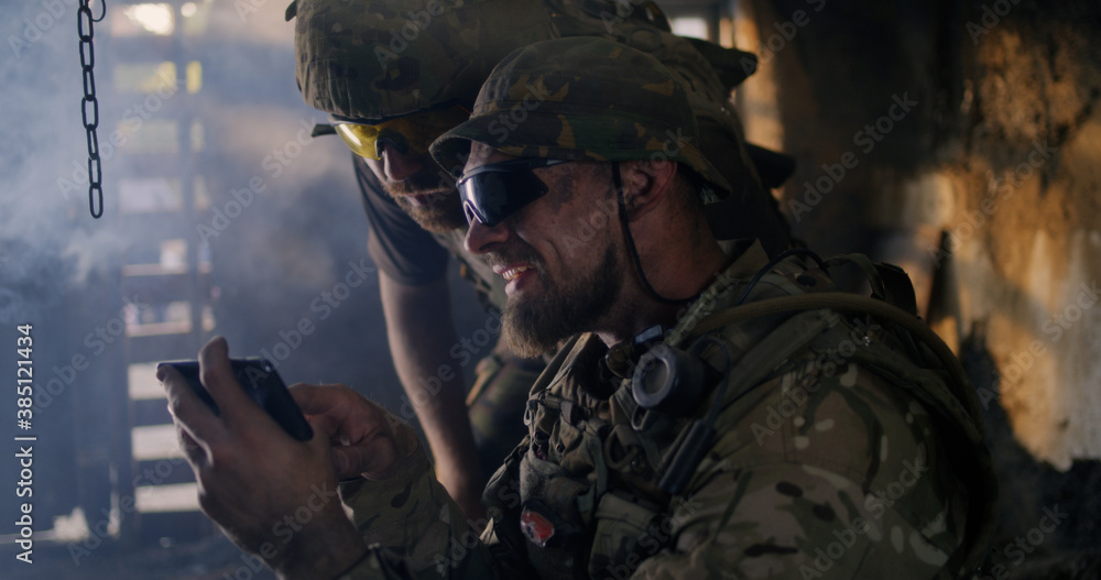 Male soldiers using smartphone together Male soldiers using smartphone together