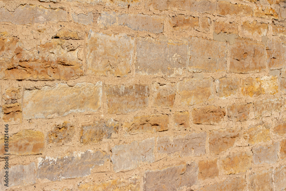 Full frame antique beige color limestone block wall texture background, with tree shadows and copy space Full frame antique beige color limestone block wall texture background, with tree shadows and copy space