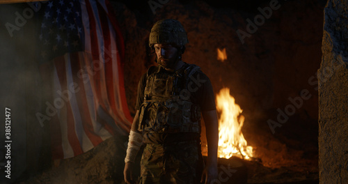 Wounded soldier near fire and USA flag