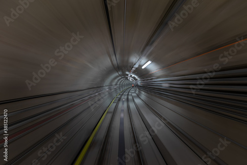 Construction site of the subway tunnel with blurred light tracks. Underground facility leading deep down.