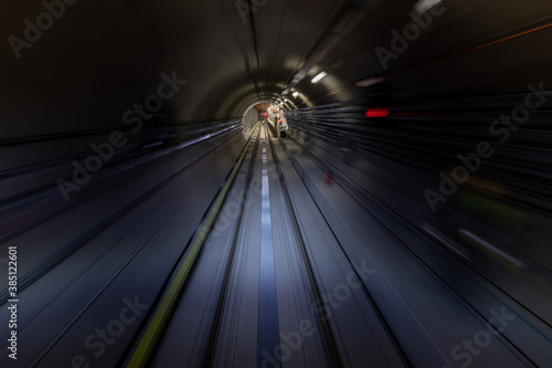 Construction site of the subway tunnel with blurred light tracks. Underground facility leading deep down.