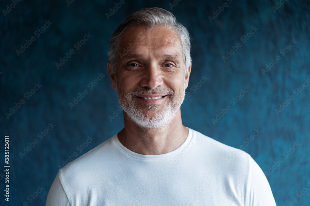 Obraz premium Casual Grey-haired Mature handsome man portrait over dark blue wall background