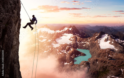 Epic Adventurous Extreme Sport Composite of Rock Climbing Man Rappelling from a Cliff. Mountain Landscape Background from British Columbia, Canada.