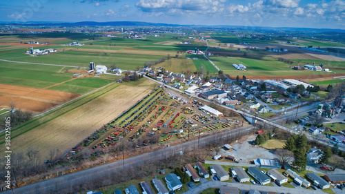 Aerial View of an Amish Mud Sale with Lots of Buggies and Farm Equipment