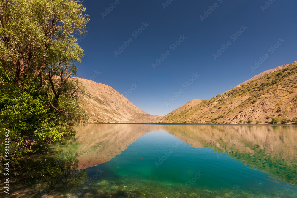 Mountain lake of Gahar, Iran in the Zagros mountains, with a few trees nearby