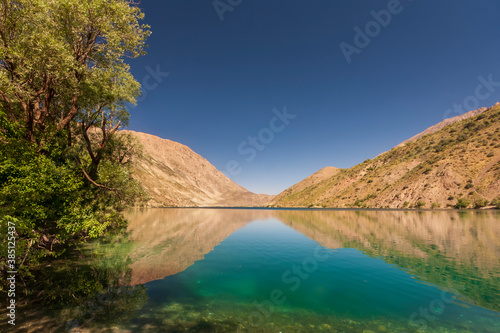 Mountain lake of Gahar, Iran in the Zagros mountains, with a few trees nearby photo