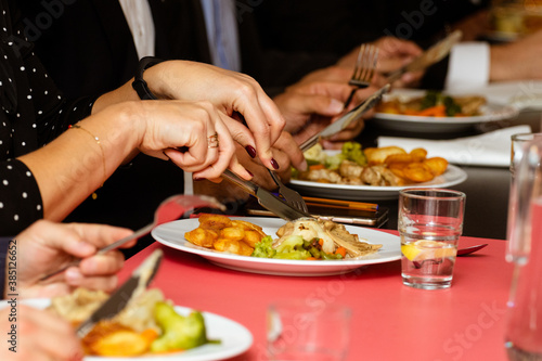 Woman's hands have dinner in a restaurant. Many visitors eat their meals in the restaurant. Tasting