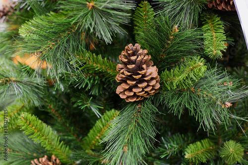 brown cone on artificial Christmas tree, close-up. Christmas background