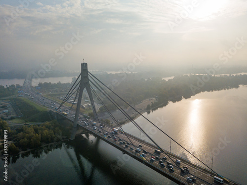 Aerial drone view. North bridge in Kiev in the rays of a sunny morning. Autumn haze in the air  cars are driving across the bridge.