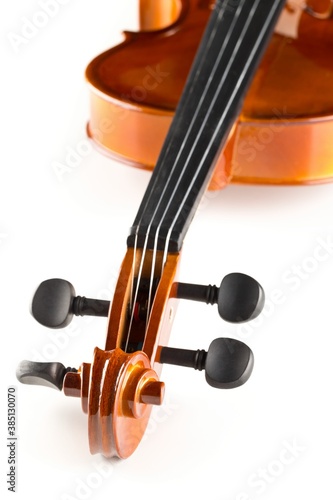 Close up macro of scroll on brown wooden fiddle or violin, classic musical instrument, over white background