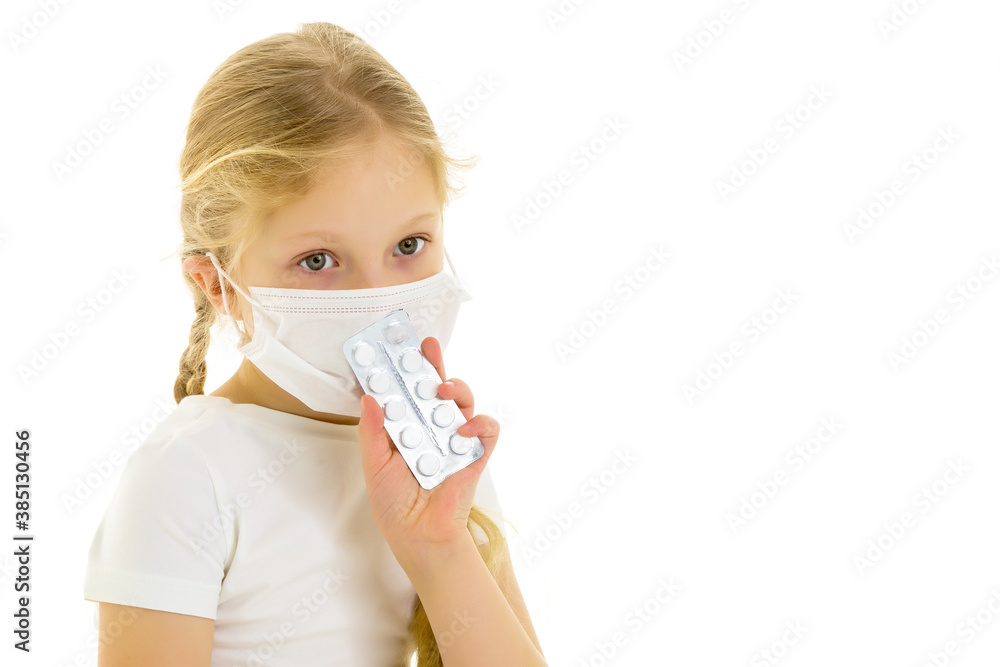 Little girl in a medical mask.She holds a pack of pills in her hand. Disease concept, covid-19. Little girl in a medical mask.She holds a pack of pills in her hand. Disease concept, covid-19.