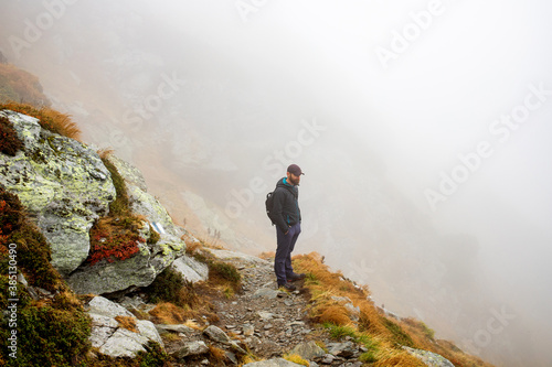 handsome male hiker in foggy mountains social distancing