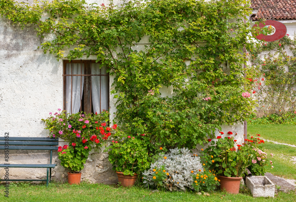 Exterior of an old traditional rural building deorated with plants and flowers