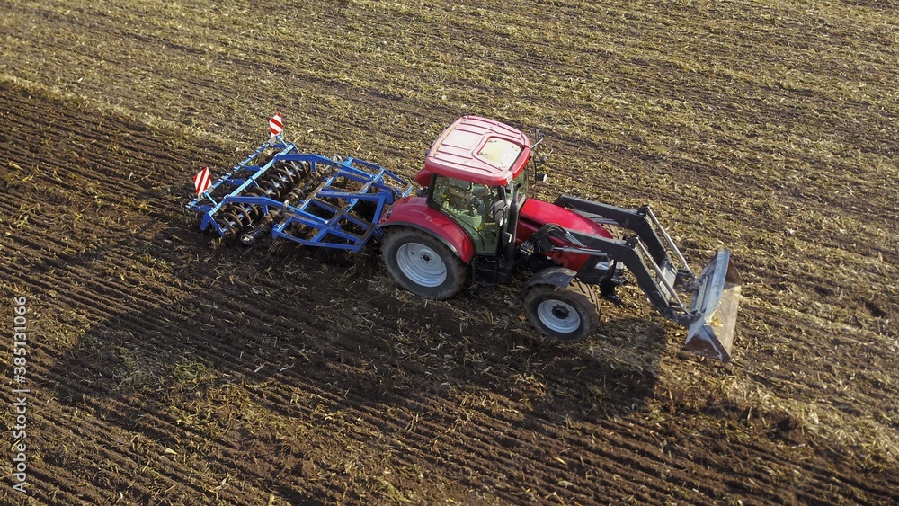 Landwirt grubbert Acker mit Traktor und Grubber, Landwirtschaft Stock