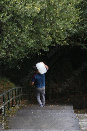 Man carrying a plastic bottle to work in his orchard