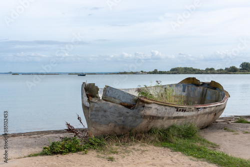 An old broken boat on the shore.
