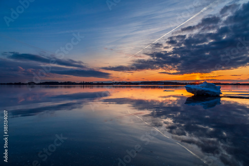 Foto Vibrant and serene winter landscape with a single frozen ice sheet floating on a lake during a late sunset in Charlottetown, Prince Edward Island, Canada