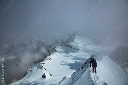 Mountaineer on a ridge in the swiss alps